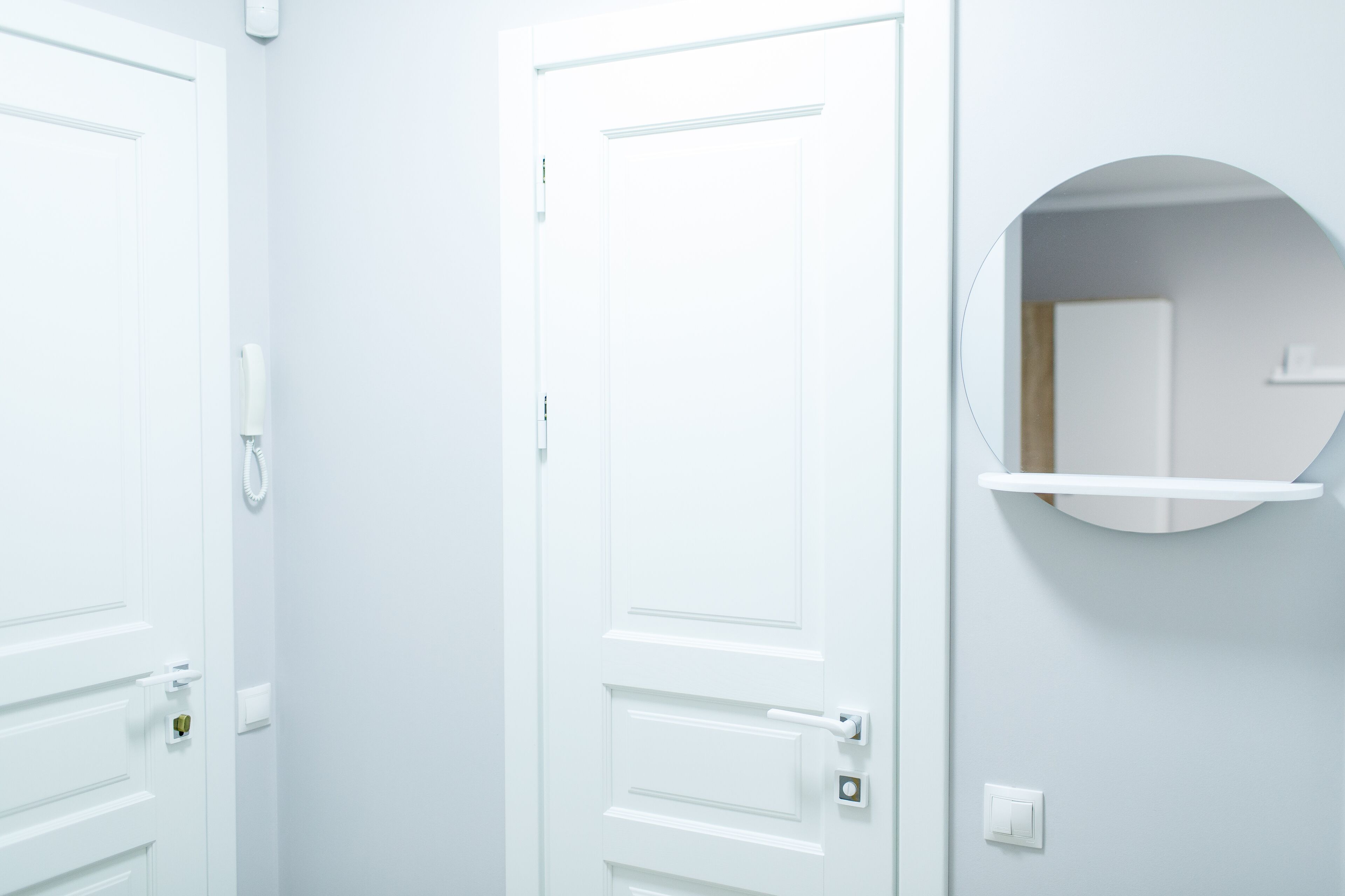 A white door with a handle, a doorbell, and a lock.
