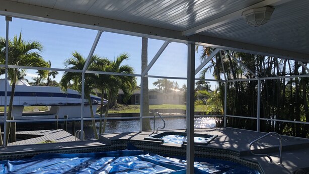 Una piscina interior con vista a un barco y palmeras.