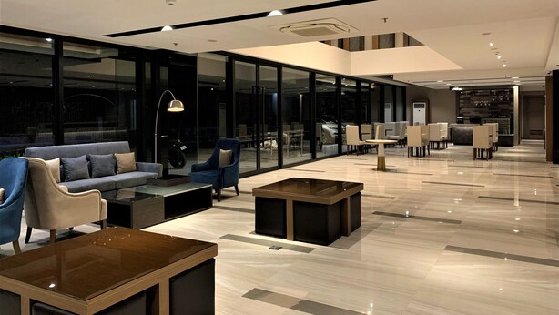 Un hall d’entrée moderne avec un canapé, des fauteuils et une table basse.