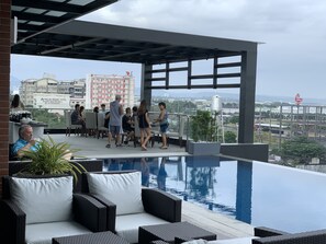 Una piscina al aire libre, sillones reclinables de piscina