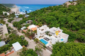 A coastal resort with a pool, multiple buildings, and lush greenery. - Surfside Condo with Private Pool – 3 Minutes to the Beach (Huatulco)