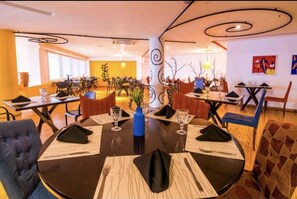 A dining area with round tables, black tablecloths, and blue vases. - Apartamento Luxo em Hotel - Beira Mar Fortaleza (Fortaleza)