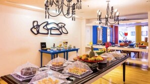 A buffet setup with covered food items and a decorative wall piece. - Apartamento Luxo em Hotel - Beira Mar Fortaleza (Fortaleza)
