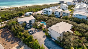 An aerial view of a coastal residential area with modern houses, a swimming pool, and a beach in the background. - Your Private Inlet Beach Escape Awaits-Top Floor, Gulf Views, Community Pool (Inlet Beach)