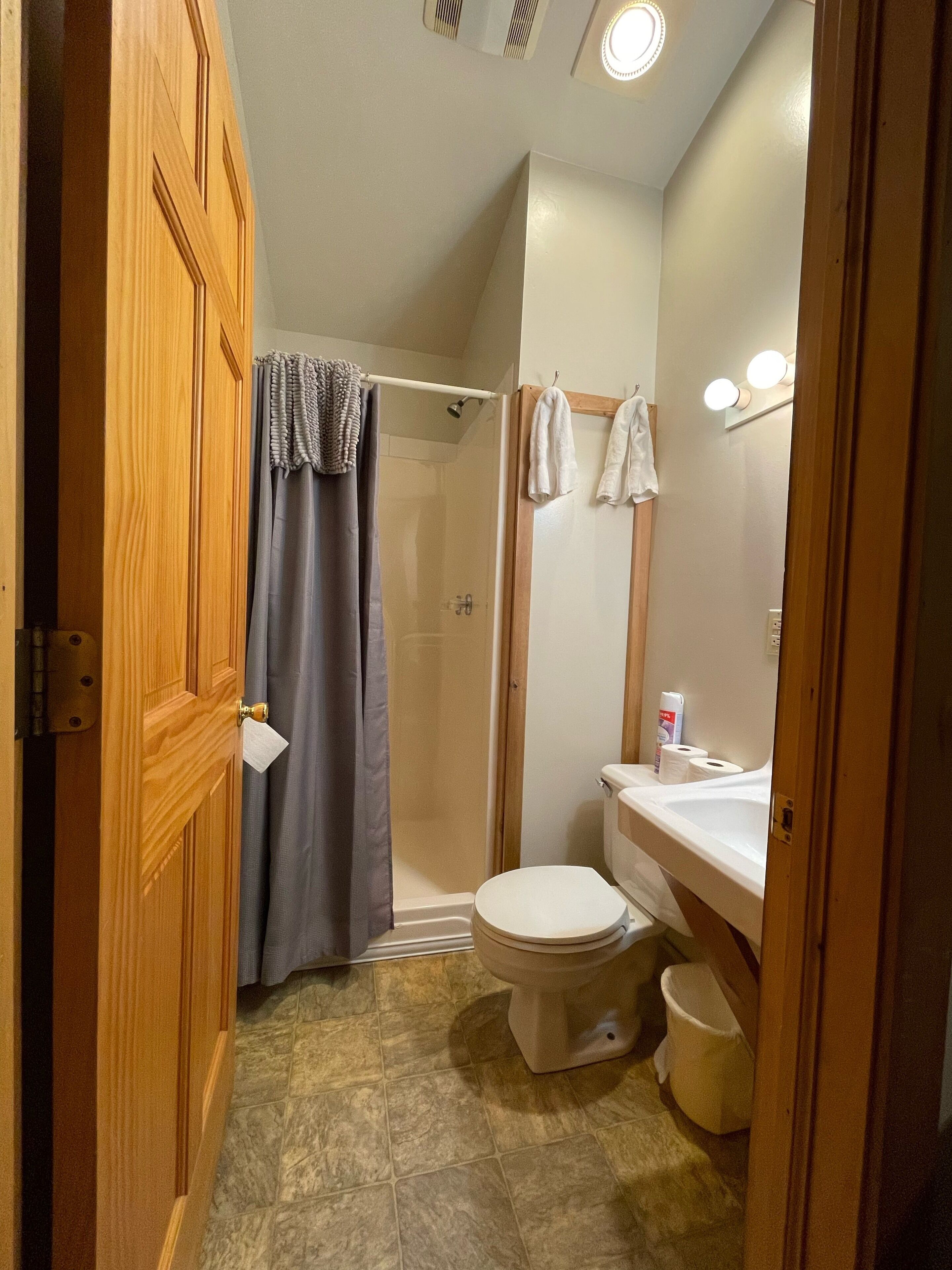 Un baño con ducha, inodoro y lavabo.