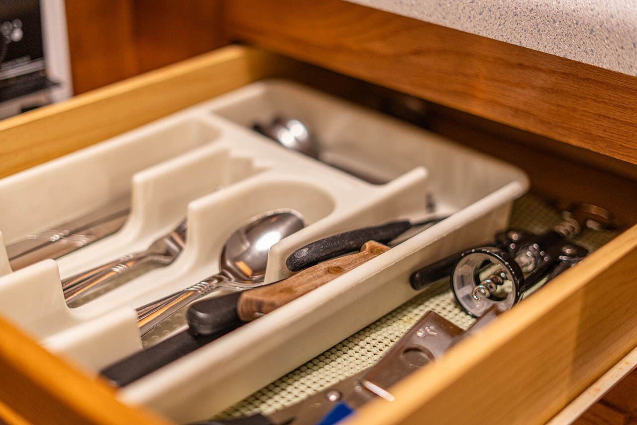 Un tiroir compartimenté contenant divers ustensiles et outils de cuisine.