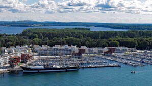 Un puerto deportivo con barcos amarrados, rodeado de edificios residenciales y un área boscosa.