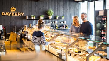 A bakery counter with various baked goods, a sign reading "BAYKERY," and a refrigerated display case.