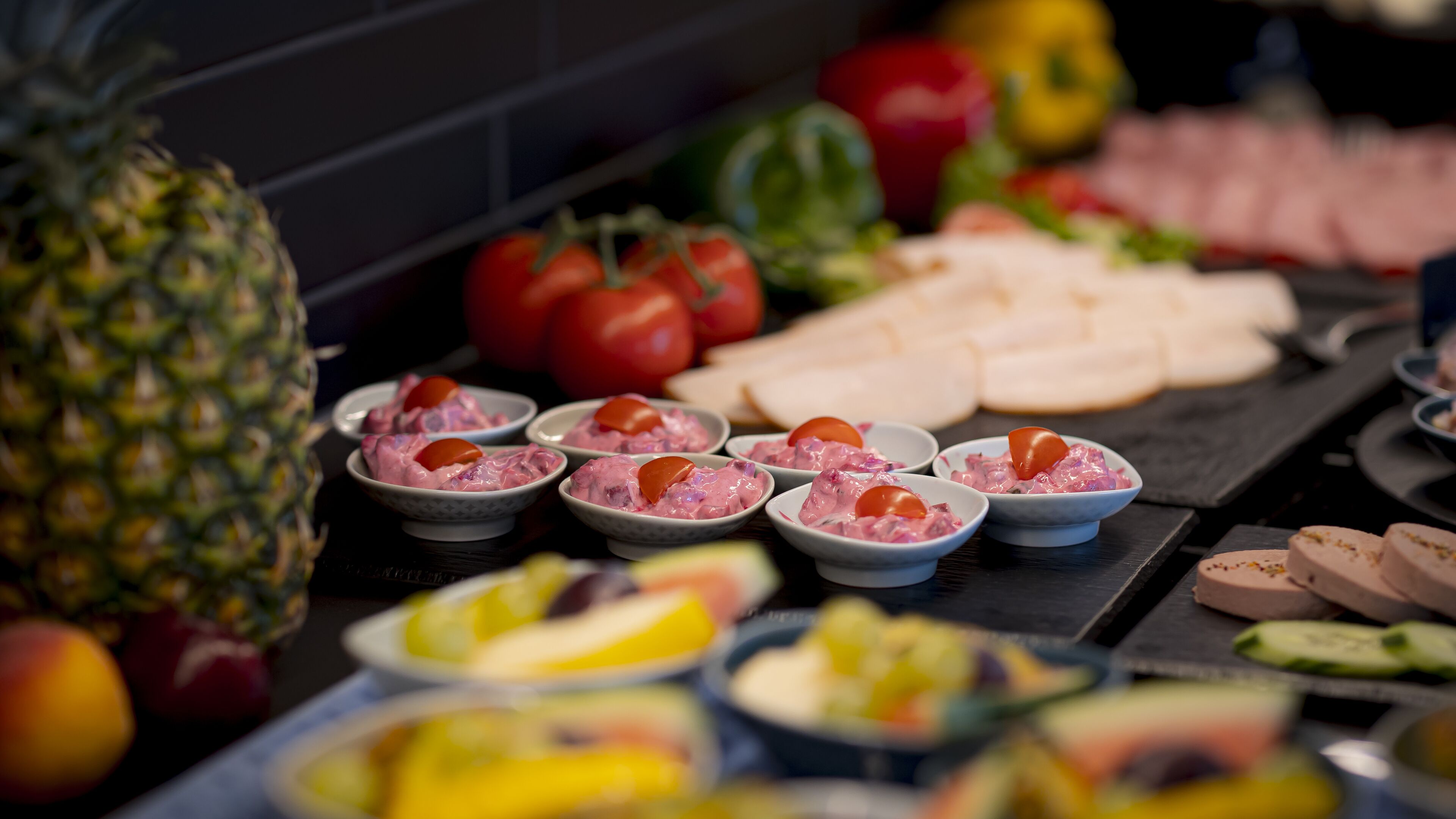 A buffet with various food items including fruits, vegetables, and prepared dishes.