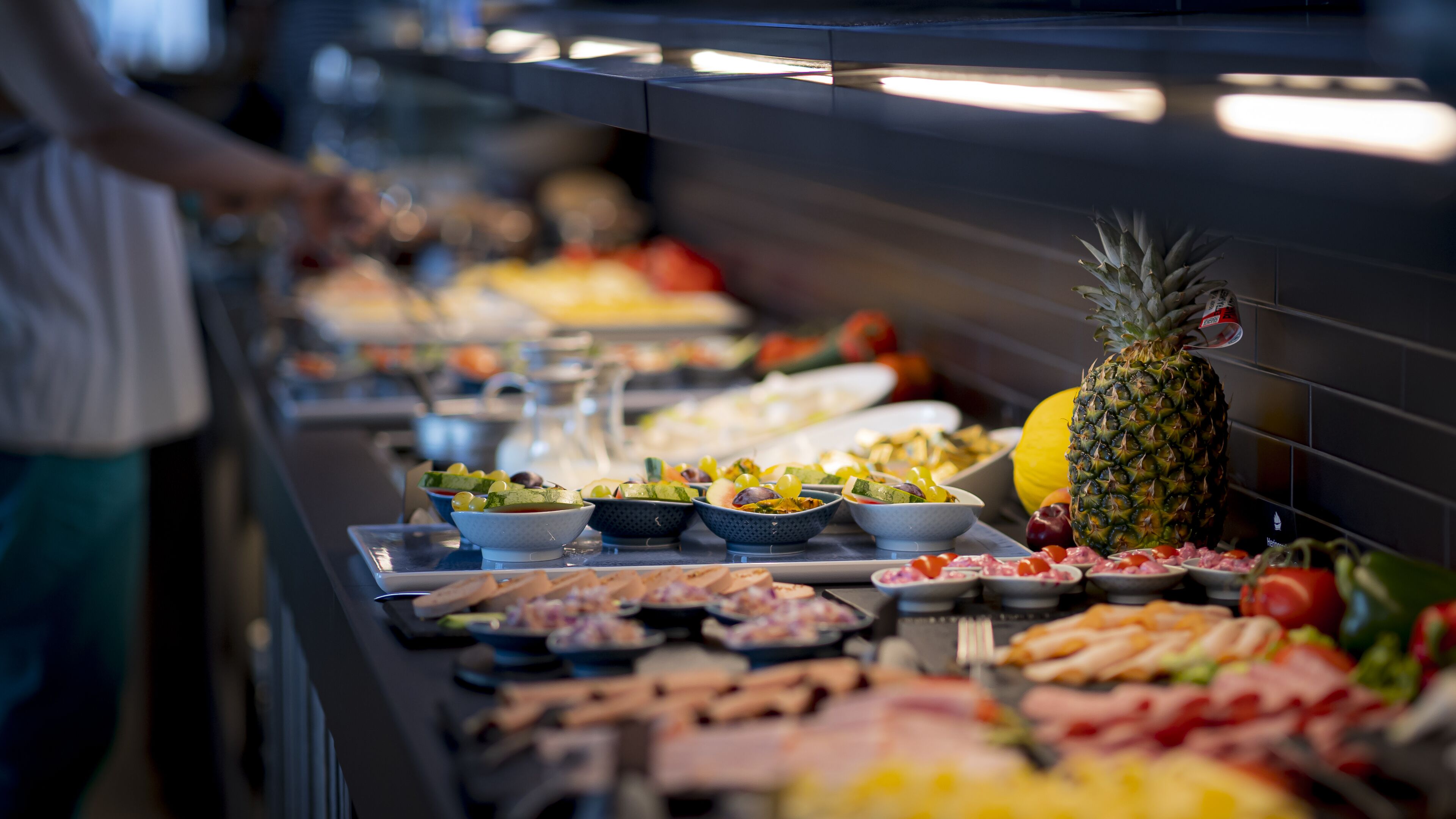 Un buffet con diverse pietanze, tra cui frutta, insalate e carni.