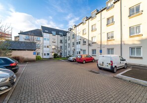 Un immeuble résidentiel à plusieurs étages doté d’un espace de stationnement.