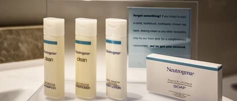 Une présentation de produits Neutrogena, comprenant du shampoing, de l’après-shampoing et de la lotion pour le corps, ainsi qu’un savon et un panneau indiquant les objets oubliés.
