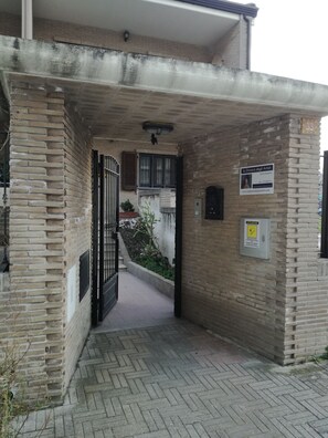 An entrance with a brick archway, a gate, and a signboard. - La Dimora Degli Artisti (Foggia)