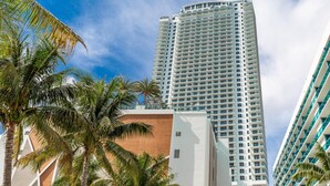 A tall, modern hotel with a curved facade, multiple balconies, and a view of palm trees. - Relaxing Getaway with Intracoastal Views (Hollywood)