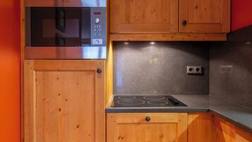 A kitchen with wooden cabinets, a built-in microwave, and a gas stove.
