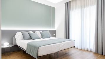 A modern bedroom with a bed, bedside table, and a large window with curtains.