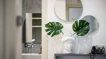 A bathroom with a white vanity, a white bust sculpture, and a telephone.