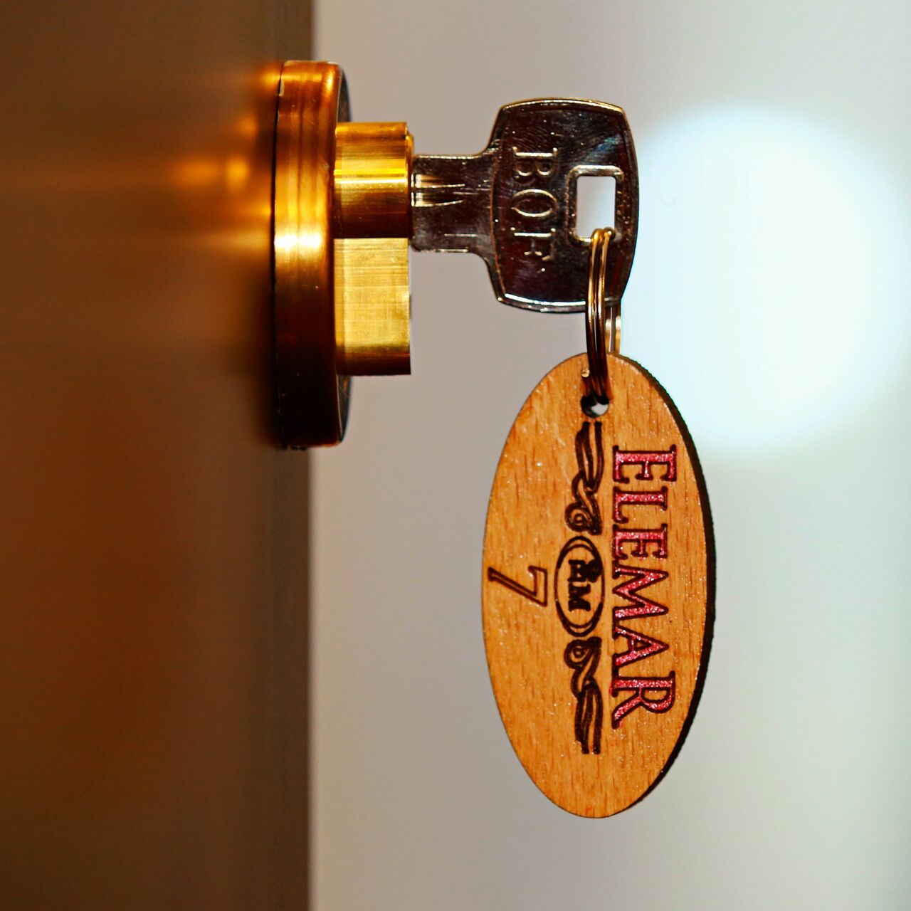 A key with a wooden tag attached, engraved with "ELEMAR 7".