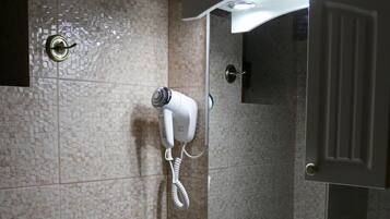 Un baño con lavamanos, espejo y toallero.