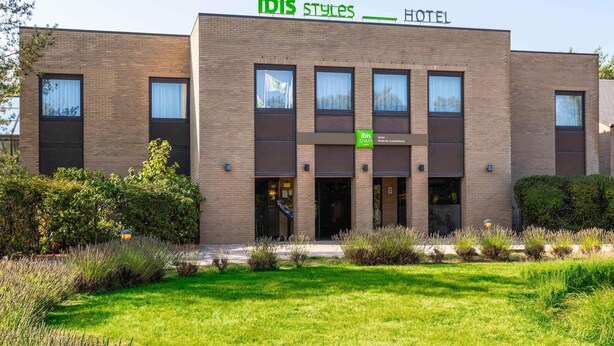 Un moderno edificio de hotel con un letrero que dice "ibis Styles HOTEL" y "Arton Porte du Luxembourg".