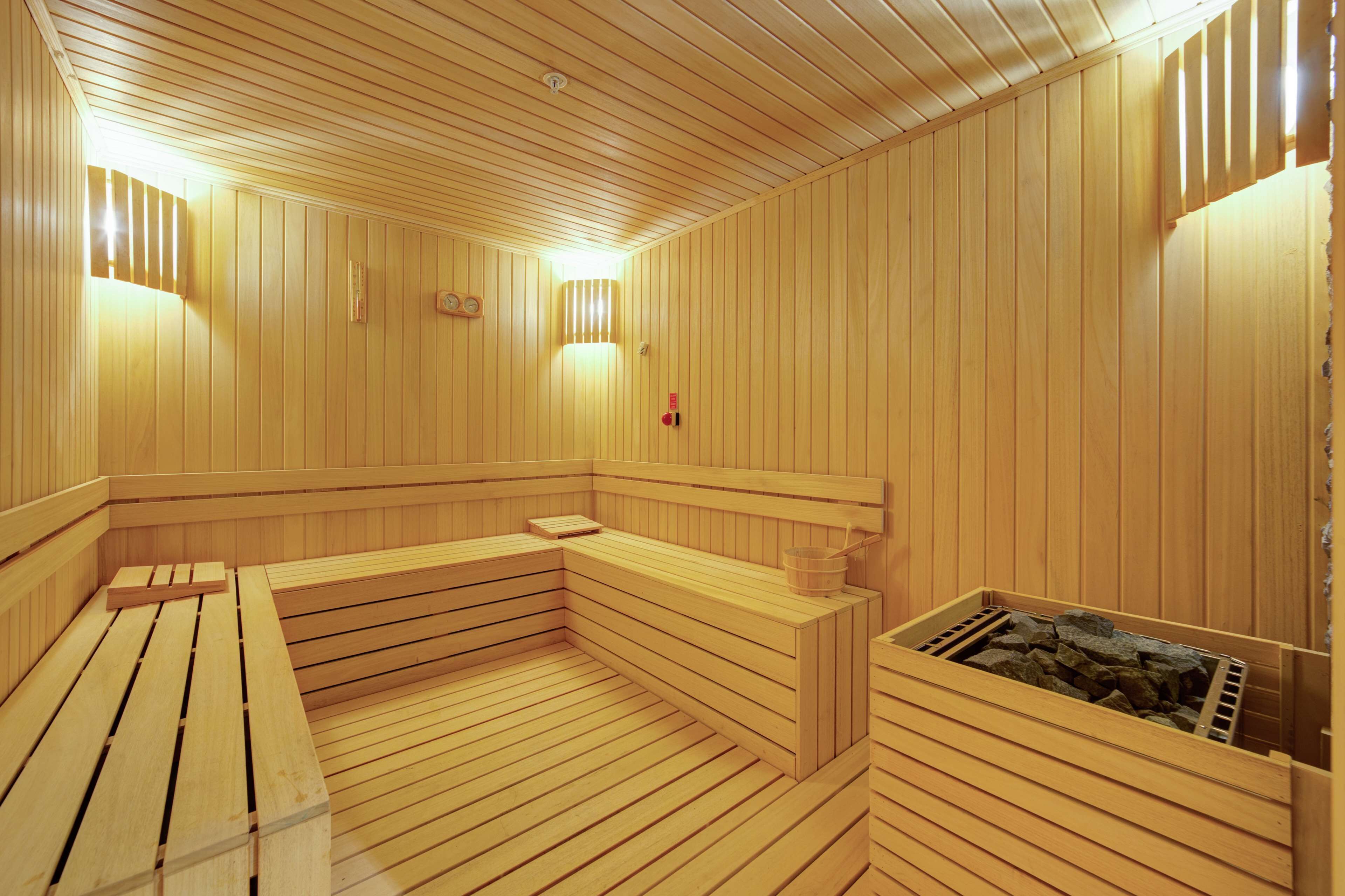 Una sauna de madera con bancos, un banco con una toalla y otro banco de madera con una toalla.