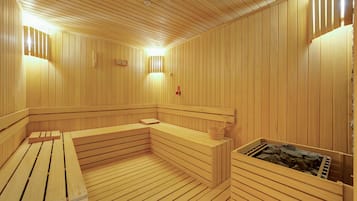 Una sauna de madera con bancos, un banco con una toalla y otro banco de madera con una toalla.