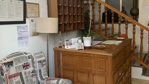 Ein Zimmer mit einer hölzernen Kommode, einer Uhr und einem an der Wand befestigten Globus.