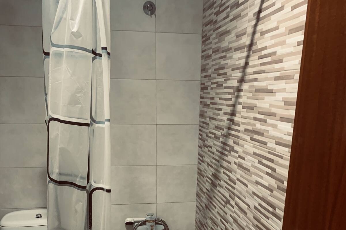 Une salle de bain avec une baignoire, des toilettes et un rideau de douche.