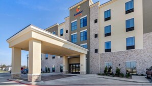 A Comfort Suites hotel with a covered entrance, multiple windows, and a brick facade. - Comfort Suites San Antonio Ft. Sam Houston/SAMMC Area (San Antonio)