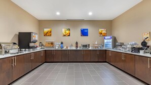 A modern kitchen with a long counter, equipped with a coffee machine, microwave, and various food items. - Comfort Suites San Antonio Ft. Sam Houston/SAMMC Area (San Antonio)