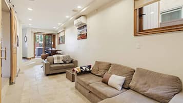 A living room with a sofa, a coffee table, and a dining area with a table and chairs.