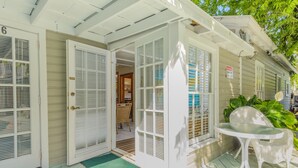 Une maison avec une véranda, une table et une chaise.