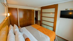 Une chambre d’hôtel avec un lit, une télévision et une armoire.