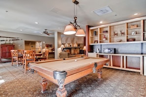 Relax in this spacious room with a pool table and comfortable seating, perfect for unwinding. Enjoy a fully equipped kitchen and dining area.