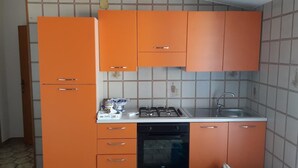 A kitchen with orange cabinets, a gas stove, a dishwasher, and a sink. - B&B Maia House (Santo Stefano di Camastra)