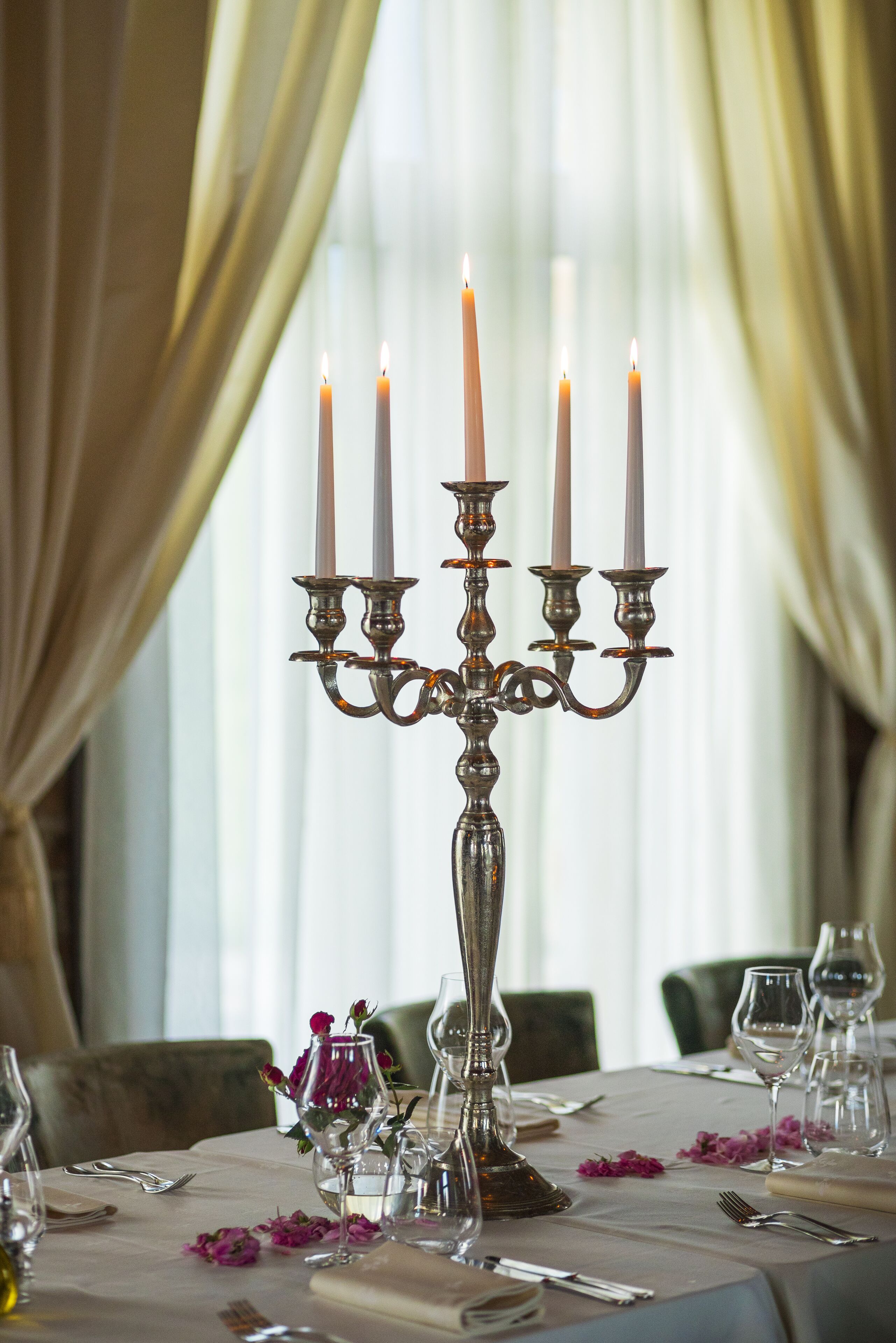 A table set for dining with a candelabra, wine glasses, and cutlery.