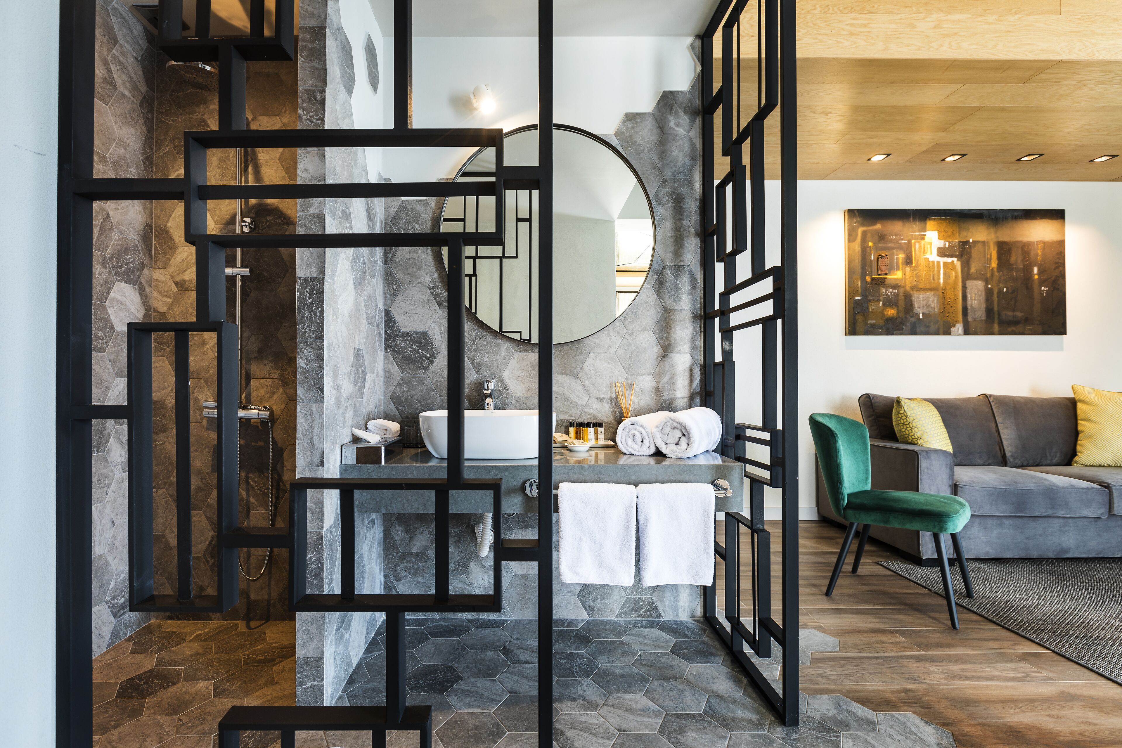 Une salle de bain moderne avec une baignoire sur pieds, un miroir rond et un plafond en bois.