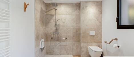 A modern bathroom with a shower, toilet, and bathtub.