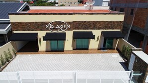 A building with a sign reading "MIRAGEM" and a tiled roof. - Residencial Miragem Bombinhas Duo (Bombinhas)
