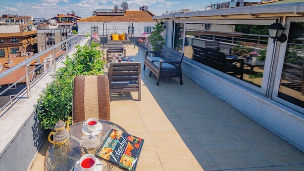 Eine Dachterrasse mit einem Tisch für zwei Personen, einem Teekessel und einer Speisekarte.
