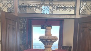 A stone fountain in a lobby with a view of the sea through large windows. - Luxury villa in Cabo San Lucas (Cabo San Lucas)