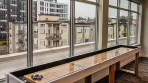 A room with large windows offering views of residential buildings. - Domicile Suites at Venn on Main (Bellevue)