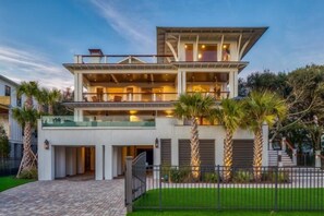Relax on the upper-level balcony with a view of the well-maintained lawn and palm trees.