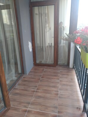 Enjoy the serene views from this balcony with a glass door leading to a spacious interior.