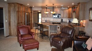 A spacious kitchen with wooden cabinets, a central island, and a dining area with leather chairs. - 30 steps to lake, Dock for fishing & swimming, Families Welcome!   (Miltona)