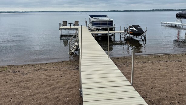 A wooden dock leading to a boat dock with a covered seating area and a covered vehicle. - 30 steps to lake, Dock for fishing & swimming, Families Welcome!   (Miltona)