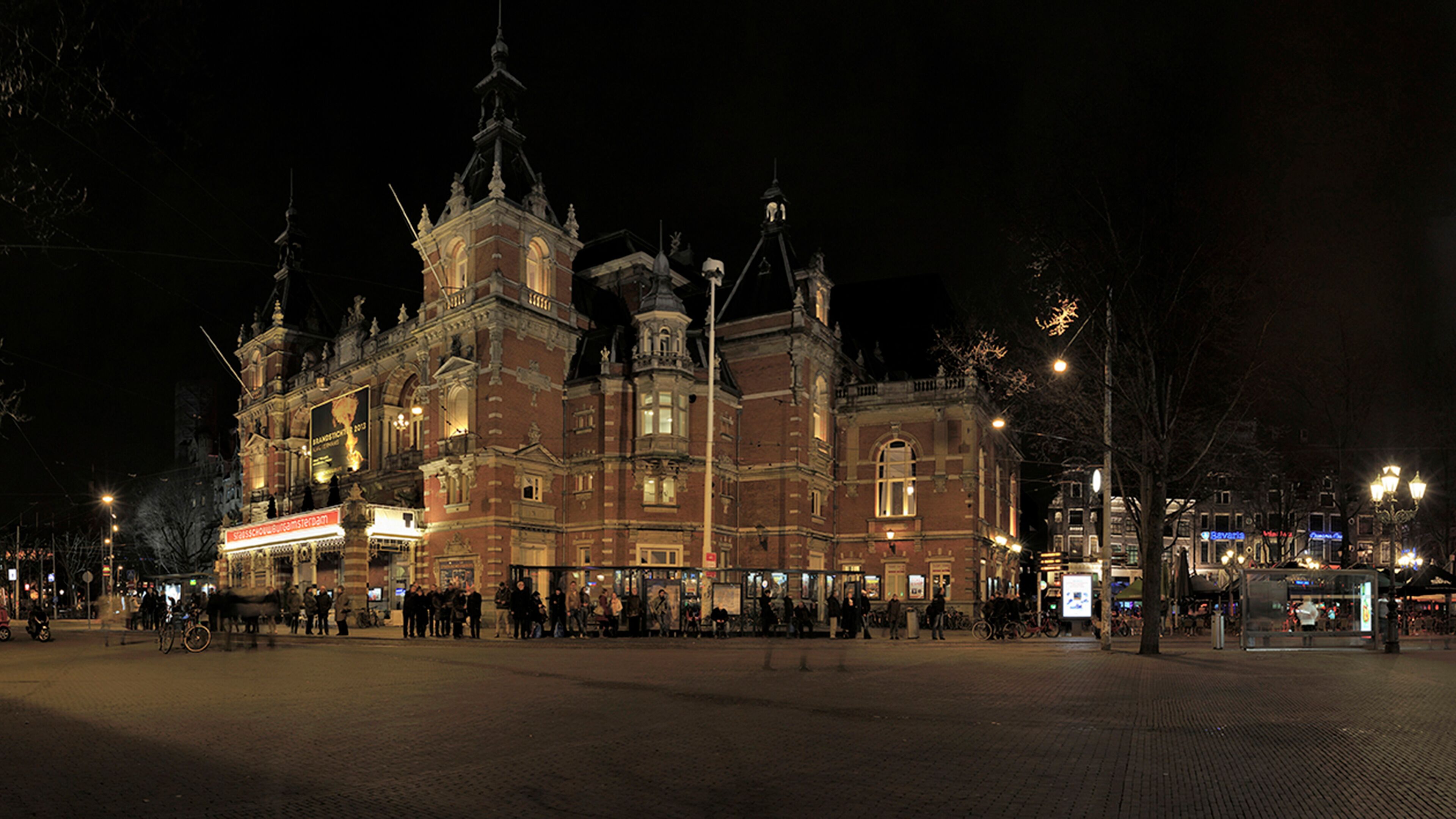 En historisk byggnad med utsmyckad arkitektur, ett centralt torn och ett stort, öppet torg.