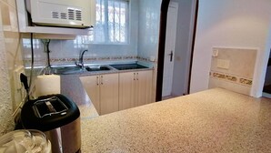 A kitchen with a sink, countertop, cabinets, a microwave, and a toaster. - Americas II Holiday Home (Playa de las Américas)
