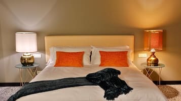 A hotel room with a bed, two pillows, a blanket, and two bedside lamps.