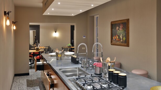 Una cocina moderna con electrodomésticos de acero inoxidable, una encimera amplia y un comedor al fondo.